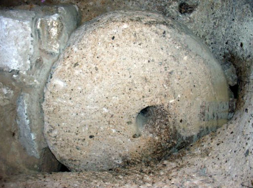 One of the heavy stone doors. They have a height of 1–1,5 m, 30–50 cm in width and weigh 200–500 kg. The hole in the centre can be used to open or close the millstone, or to see who is outside.